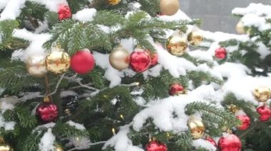 Kar ve kırmızı Gingerbread ev ile kaplı Noel ağacı asılı renkli topları panorama gösteren soldan sağa kamera hareketi. Noel ve Yeni Yıl için güzel dekore sokak