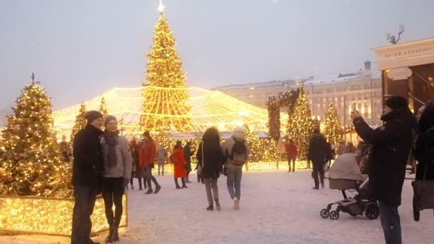 MOSCÚ - 17 DIC 2018: Año Nuevo festivo y vacaciones de Navidad en Moscú nevado. Multitud de personas camina entre los árboles de Navidad en la plaza Manezhnaya, cerca de la Plaza Roja y el Kremlin. Luces brillantes brillan — Vídeos de Stock