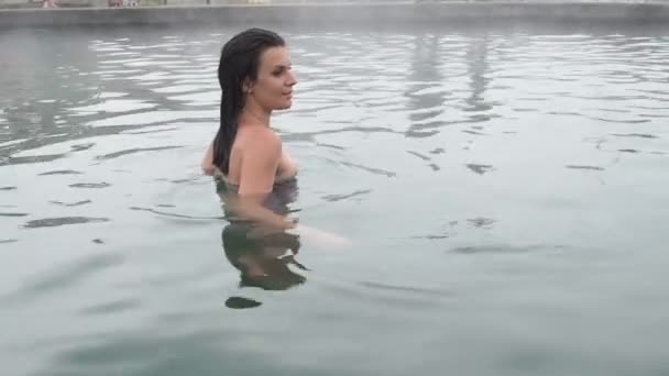 Geothermische spa. Vrouw ontspannen in warmwaterbron zwembad. Meisje genieten van zwemwater opendeurdagen bekken met in warm mineraalwater 25fps — Stockvideo