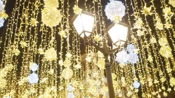Iluminación de la calle de Navidad brillante. La ciudad está decorada para las fiestas navideñas. Luces de Año Nuevo Decoración Bokeh brillante. Linternas ardientes en la calle Nikolskaya en Moscú. Brillante festivo — Vídeos de Stock