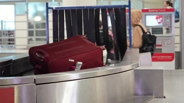 Moskou, Rusland - 6 mei 2019: Bagage claimgebied in Moskou International Airport Domodedovo. Mensen halen hun bagage op van de bewegende transportband. betreffende de transportband in de bagageband bij — Stockvideo