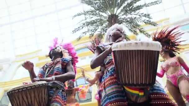 MOSKAU, RUSSLAND - 29. FEBRUAR 2020: Afrikanische Trommler in ethnischer Kleidung spielen in Großaufnahme auf der Djembe-Trommel. Musiker schlägt Rhythmus auf afrikanischen Trommeln. Schwarze Künstler schlagen mit ihren Händen auf die Trommeln. Mädchen — Stockvideo