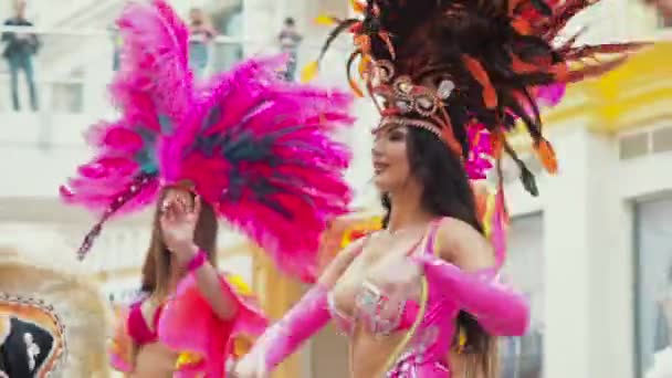 MOSCOW, Ryssland 29, 2020: Vackra flickor med lockigt hår, mörk hud, stort hår i ljusa färgglada karneval kostym dekorerad med strass dansande samba dans. Halvnakna kabarédykningar — Stockvideo