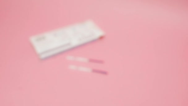 여성 손에 분홍색 배경에서 양성 임신 테스트를 들고 있는 분홍색 의료 장갑을 끼고 있습니다. 파란색 막대의 약어 HCG 는 세포에서 생성되는 호르몬을 의미 한다. — 비디오