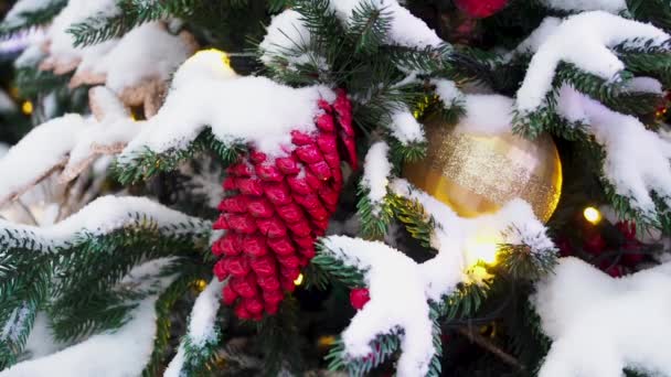 Décorations de Noël accrochées au sapin de Noël recouvert de neige dans les rues de la ville. Magnifique économiseur d'écran de Noël — Video