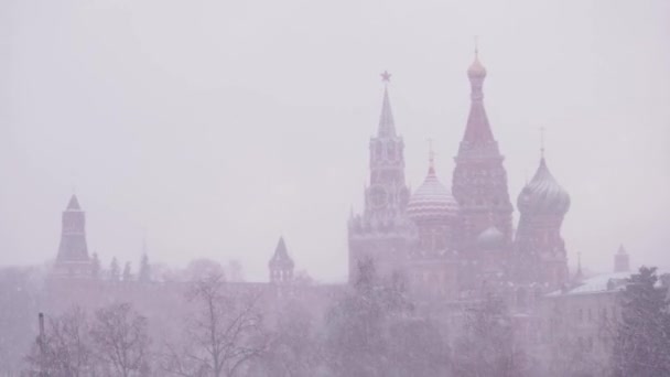 Rusya, Moskova, Karlı bir kış gününde Hendek 'teki En Kutsal Theotokos' un Şefaatinin Katedrali ve Kremlin manzarası. Şiddetli kar fırtınasında Kutsal Vasily Katedrali — Stok video