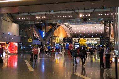 Katar 'ın Doha kentindeki Hamad Uluslararası Havalimanı' nın ulaşım salonunda gezginler..