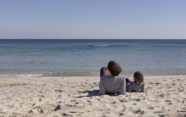 Çocuklu anneler sahilde yürümek. Kız kardeş (8 ve 7 yaşında