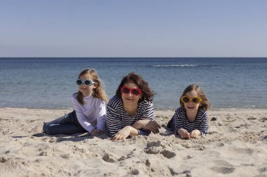 Çocuklu anneler sahilde yürümek. Kız kardeş (8 ve 7 yaşında