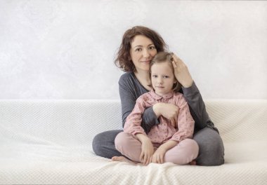 Kızı ile genç kadın kanepede dinleniyor. 