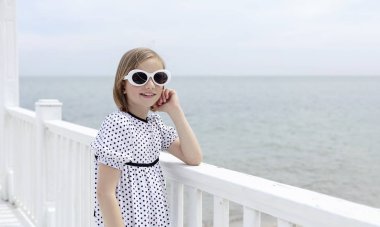 Küçük (8 yaşında) b ile beyaz bir elbise içinde oldukça neşeli kız