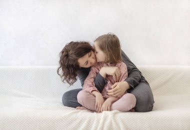 Kızı ile genç kadın kanepede dinleniyor.