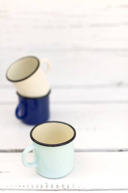 Eski ahşap arka planda retro tarzda emaye kupalar. 