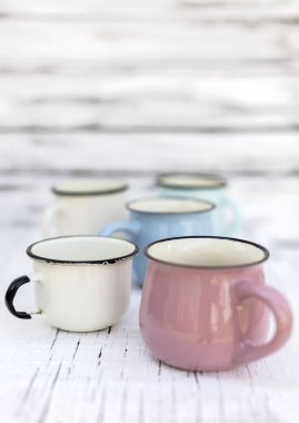 Eski ahşap arka planda retro tarzda emaye kupalar. 