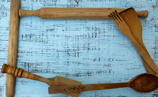 Vintage old kitchen utensils on a blue wooden background.