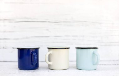 Eski ahşap arka planda retro tarzda emaye kupalar. 