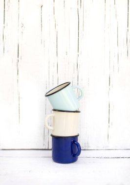 Eski ahşap arka planda retro tarzda emaye kupalar. 