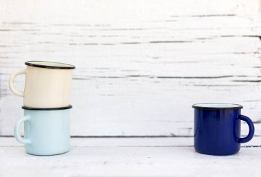 Eski ahşap arka planda retro tarzda emaye kupalar. 
