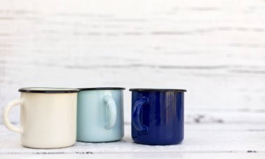 Eski ahşap arka planda retro tarzda emaye kupalar. 