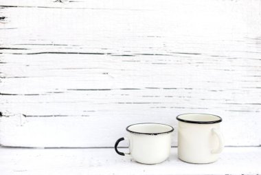 Eski ahşap arka planda retro tarzda emaye kupalar. 