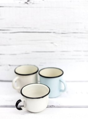 Eski ahşap arka planda retro tarzda emaye kupalar. 