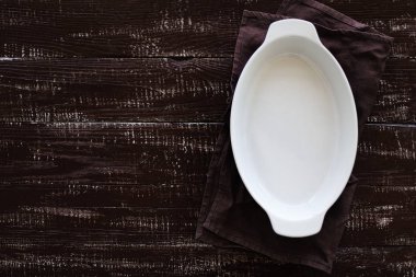 Ahşap eski arka plan üzerine seramik beyaz pişirme çanak. 