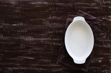 Ahşap eski arka plan üzerine seramik beyaz pişirme çanak. 