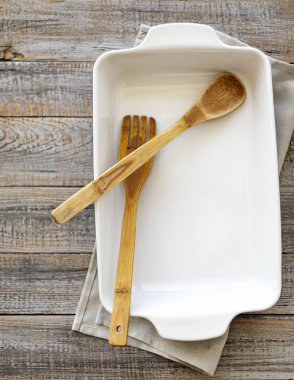 Ahşap eski arka plan üzerine seramik beyaz pişirme çanak.