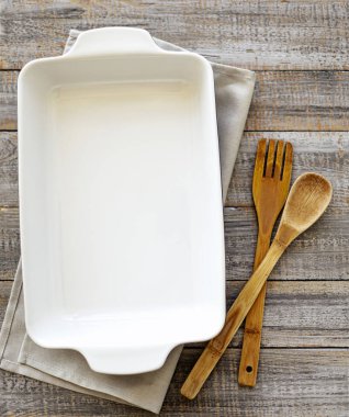 Ahşap eski arka plan üzerine seramik beyaz pişirme çanak.