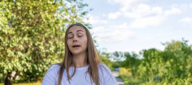 Kedi tutan bir kadın. Kadının kedilere alerjisi var. Kedi kürküne alerji