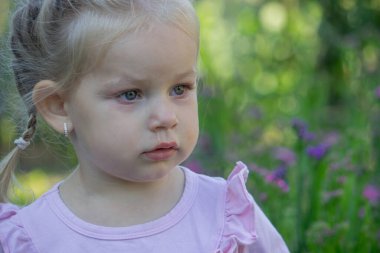 Dışarıda alerji belirtileri gösteren üzgün küçük bir kız..