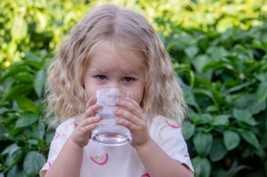 Çocuk dışarıda su içiyor. Seçici odak