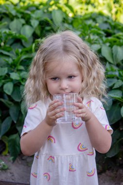 Çocuk dışarıda su içiyor. Seçici odak