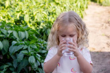 Çocuk dışarıda su içiyor. Seçici odak