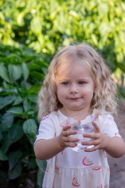 Çocuk dışarıda su içiyor. Seçici odak