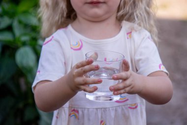 Çocuk dışarıda su içiyor. Seçici odak