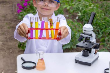 Bilim deneyleri yapan bir çocuk. Mikroskobu olan çocuk.
