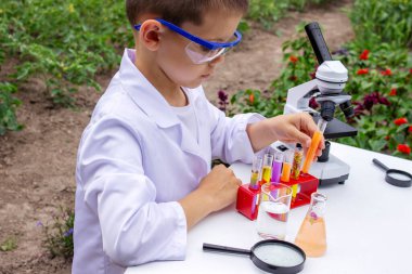Bilim deneyleri yapan bir çocuk. Mikroskobu olan çocuk.