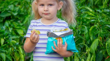 Cips yiyen kız. Sağlıksız yemek ve yaşam tarzı kavramı. Bir paket patates cipsi.