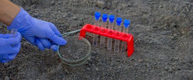 Bir bilim adamı analiz için toprağı test tüpüne koyar. Seçici odak