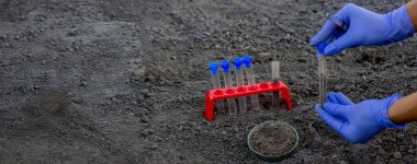 Bir bilim adamı analiz için toprağı test tüpüne koyar. Seçici odak
