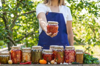 Doğanın arka planında salatalık konservesi yapan bir kadın. Seçici odak.