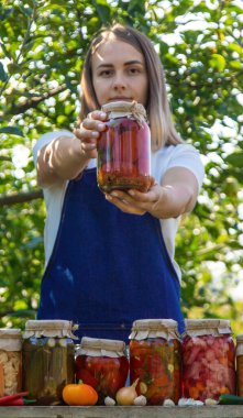 Doğanın arka planında salatalık konservesi yapan bir kadın. Seçici odak.