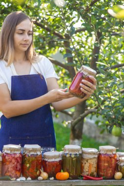 Doğanın arka planında salatalık konservesi yapan bir kadın. Seçici odak.