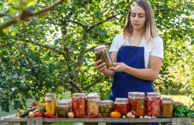 Doğanın arka planında salatalık konservesi yapan bir kadın. Seçici odak.