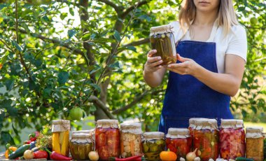 Doğanın arka planında salatalık konservesi yapan bir kadın. Seçici odak.