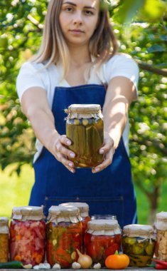 Doğanın arka planında salatalık konservesi yapan bir kadın. Seçici odak.