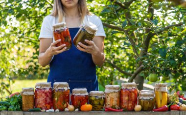 Doğanın arka planında salatalık konservesi yapan bir kadın. Seçici odak.