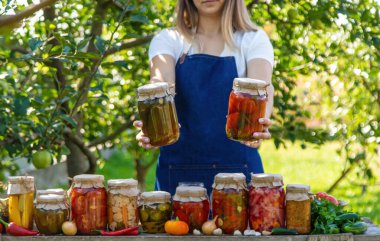 Doğanın arka planında salatalık konservesi yapan bir kadın. Seçici odak.