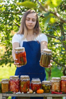 Doğanın arka planında salatalık konservesi yapan bir kadın. Seçici odak.